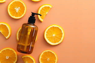Amber glass shampoo bottles with sliced orange top view. SPA natural fruit cosmetics.