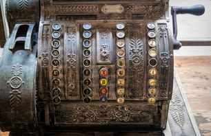 Caisse enregistreuse vintage en bronze dans un ancien magasin. Règlement en espèces avec les clients pour les achats et la comptabilité. Pratiques commerciales désuètes et traditionnelles