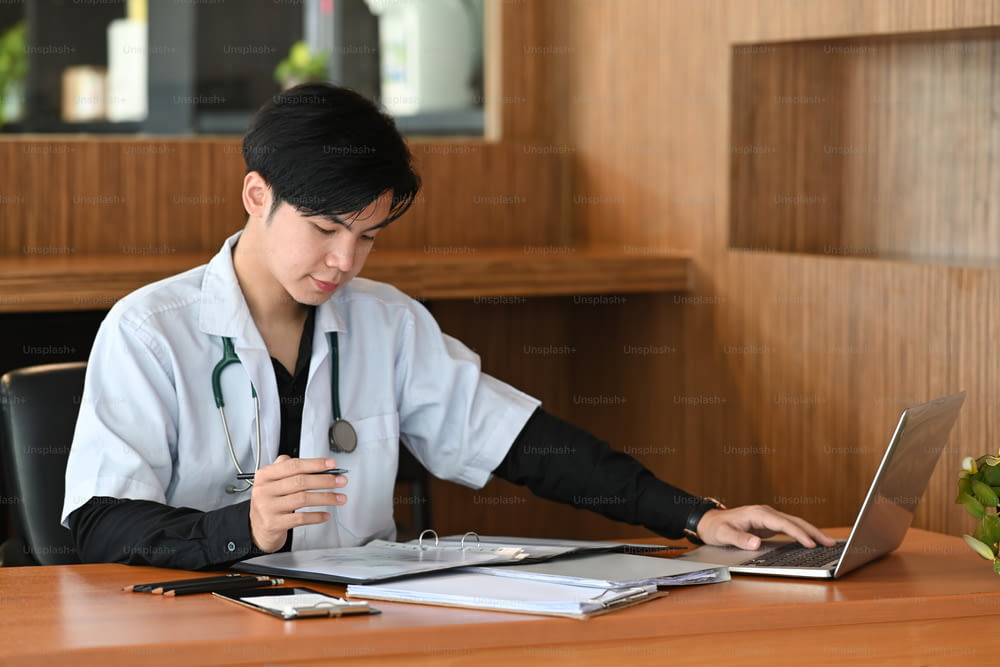 Smart doctor in white uniform working in medical clinic.