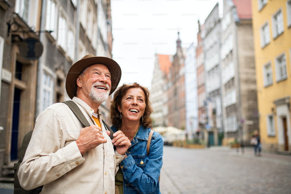 Un ritratto di felici coppie anziane turisti all'aperto nella città storica