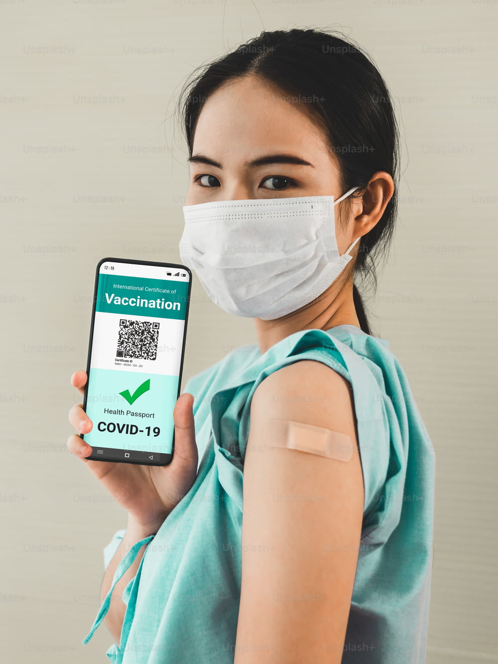 Jovem asiática mostra passaporte de vacina no celular para validar permissão de viagem pelo documento digital