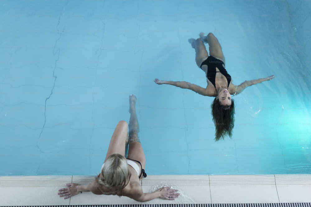 Rearview shot of two young women relaxing in the pool at a spa