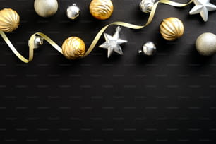 Christmas flat lay composition. Christmas frame top border made of gold and silver balls, ribbon. Luxury style.