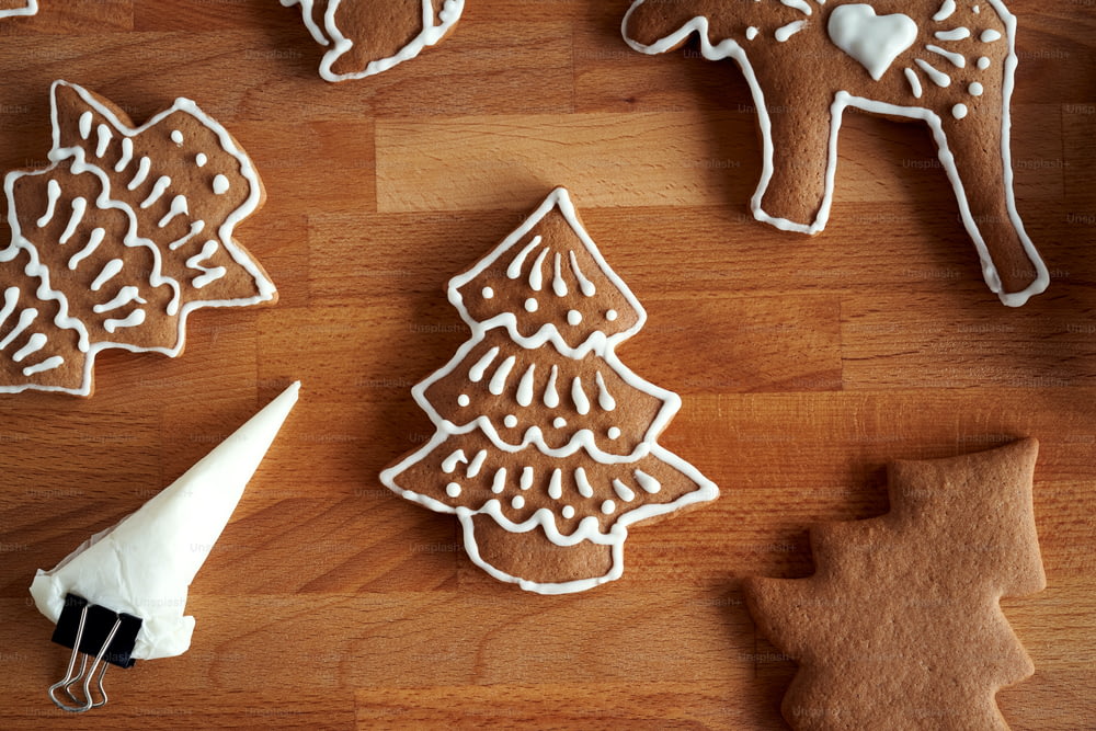 Preparation of homemade gingerbread Christmas cookies - decorating with white icing using a cornet