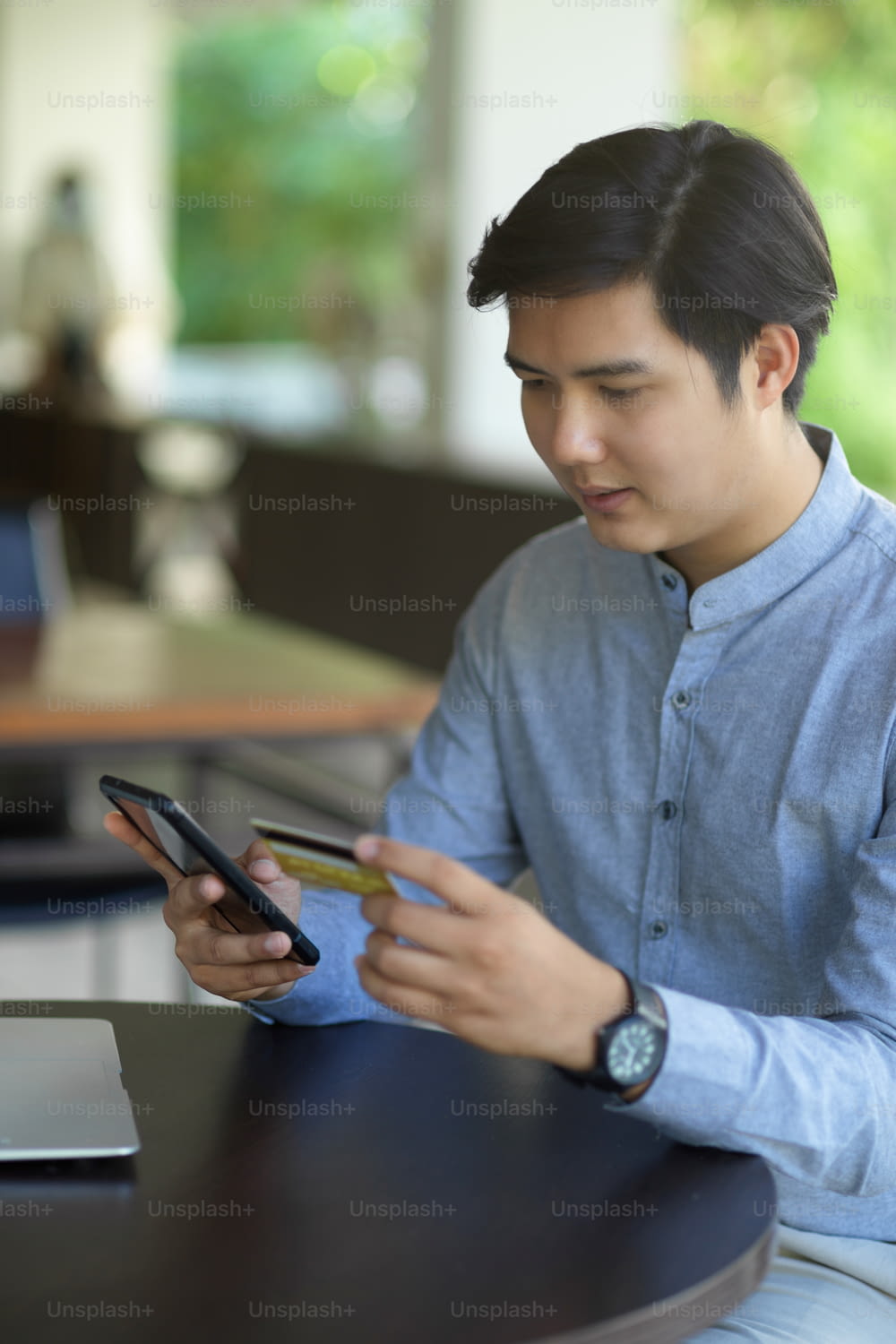 An asian man using his smartphone to connect with his credit card via internet banking application. online payment concept.