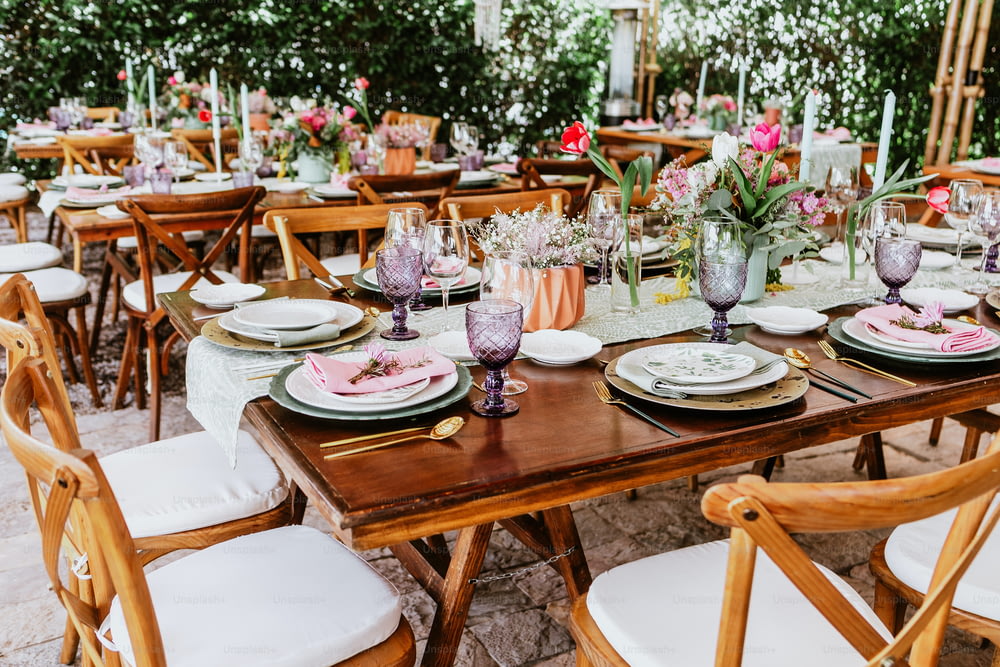 ラテンアメリカでの結婚披露宴のために飾られたテーブルの上に花と皿が置かれたテーブルのあるテラス