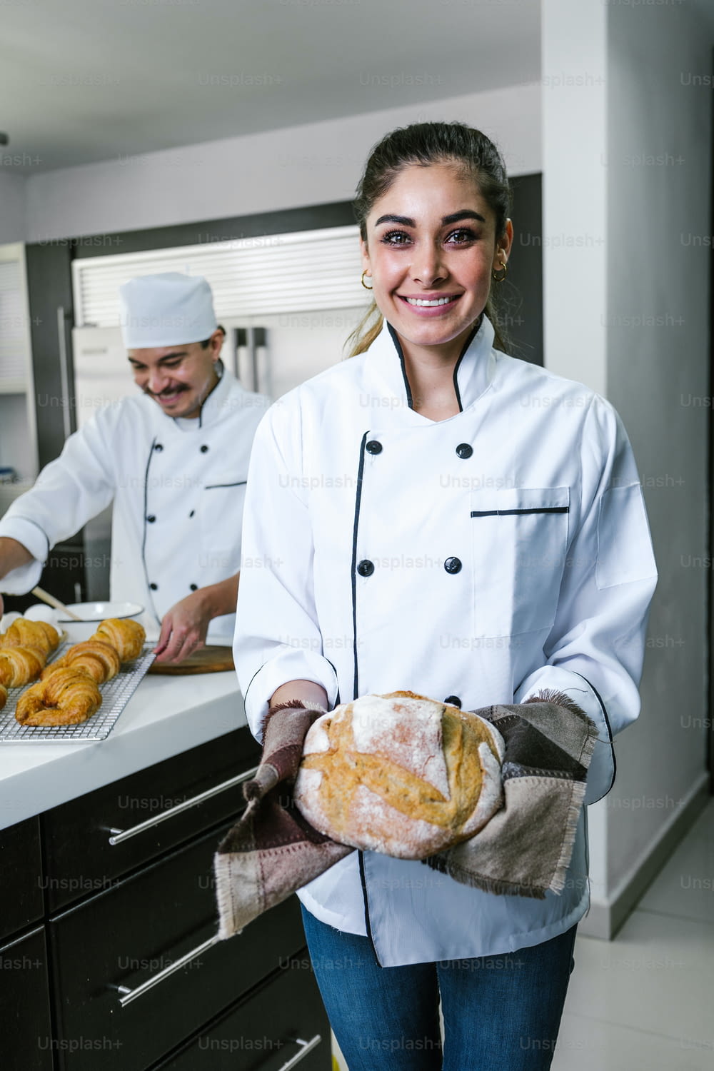 young Latin woman baker holding piece of bread at kitchen in Mexico Latin America