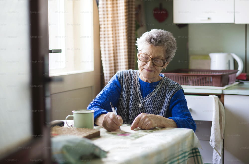 Une vieille femme est assise dans sa cuisine de style campagnard