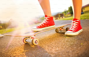 어린 스케이터 소녀의 발과 스케이트 보드 클로즈업