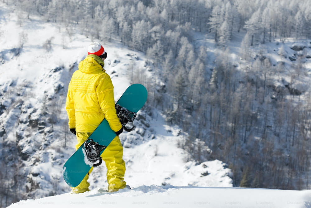 Vista trasera de un snowboarder de pie en un ventisquero en invierno Nota para el inspector: la imagen es anterior al 1 de septiembre de 2009