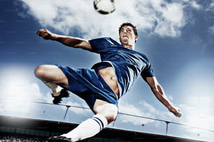 Un uomo che calcia un pallone da calcio in cima a un campo