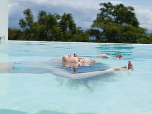 a woman floating in a swimming pool with her feet in the water