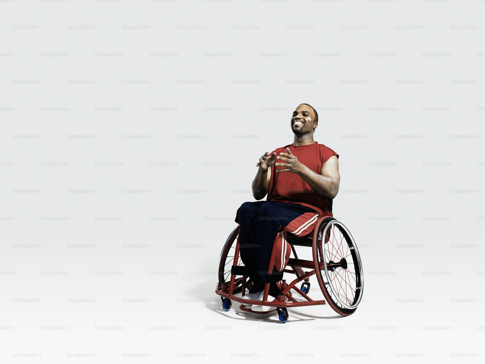 a man in a wheel chair with his hands together