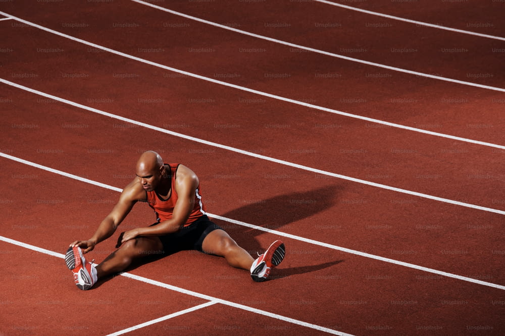 African American athlete stretching on running track