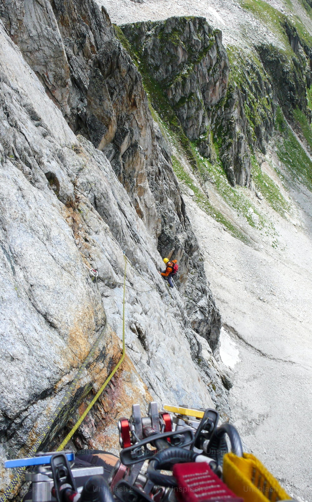 スイスのアルプスにあるピッツォフォルチェッラのハードアルペンルートでロッククライマーがモバイル保護を配置