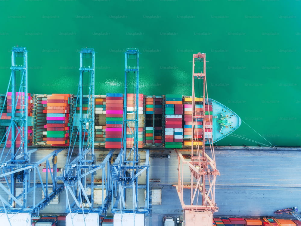Buque portacontenedores de vista superior aérea en el puerto marítimo y contenedor de carga de puente grúa de trabajo para importación, exportación, envío o fondo del concepto de transporte.
