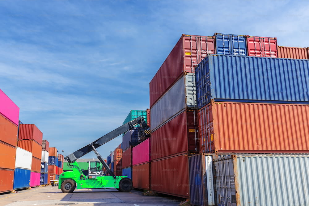 Gabelstapler arbeiten im Containerlager mit schönem Himmel für Logistikversand, Importexport oder Transport.