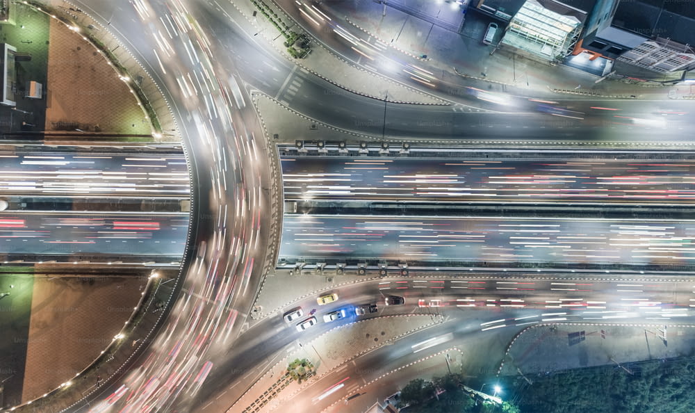 Vista aérea superior da rodovia interseção de estrada rotatória ou círculo à noite para transporte, distribuição ou fundo de tráfego.