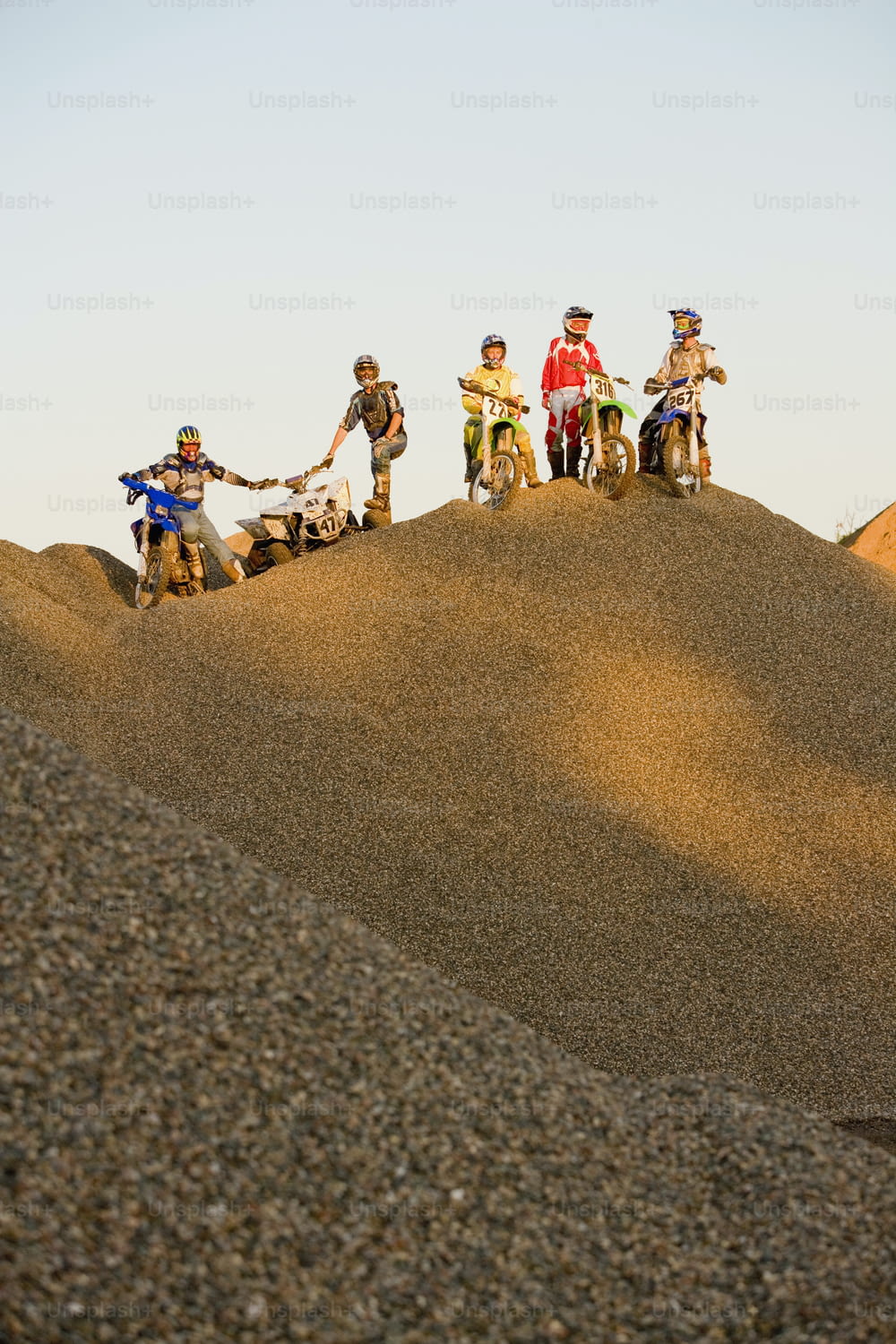 a group of people riding dirt bikes on top of a hill