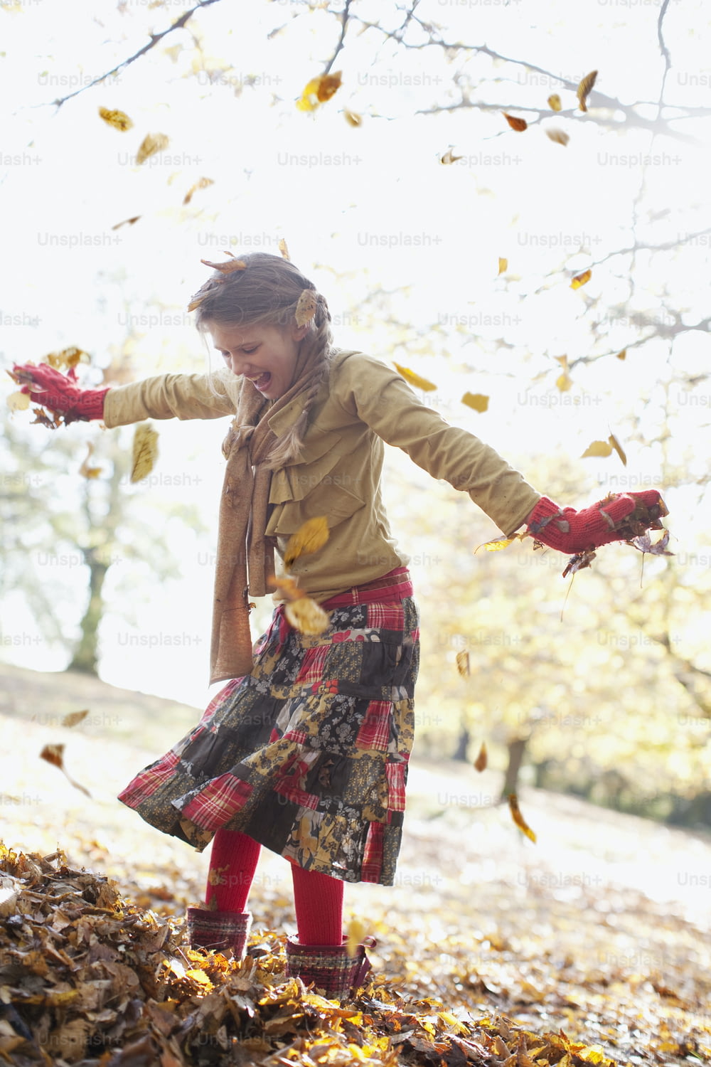 Une jeune fille lançant des feuilles en l’air
