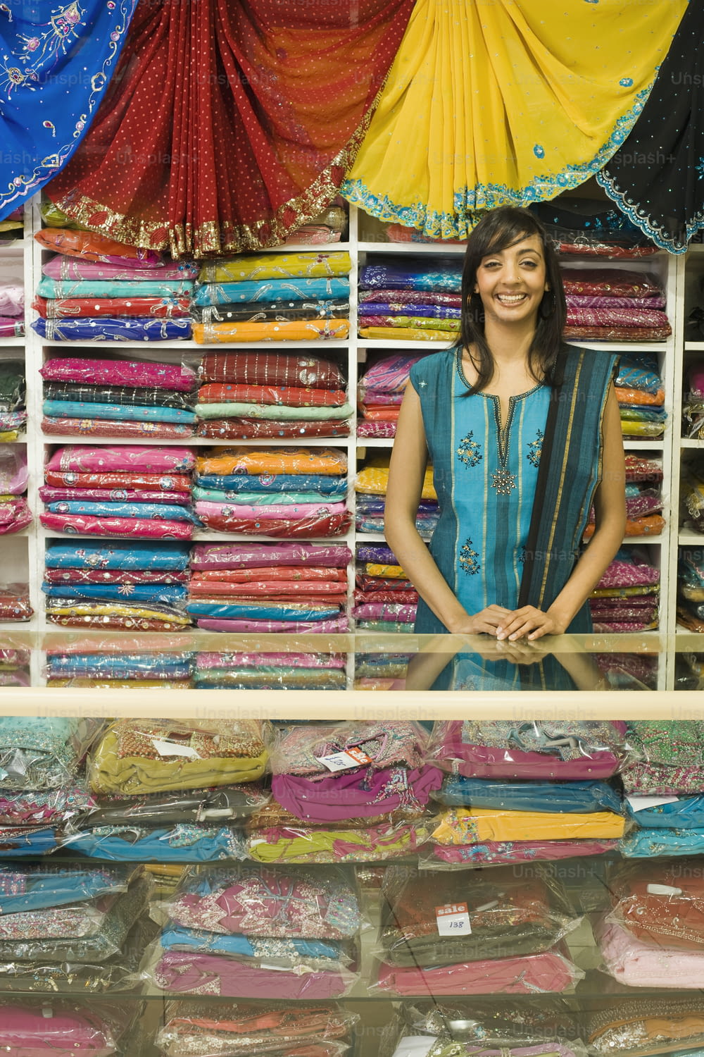 a woman standing in front of a display of fabrics