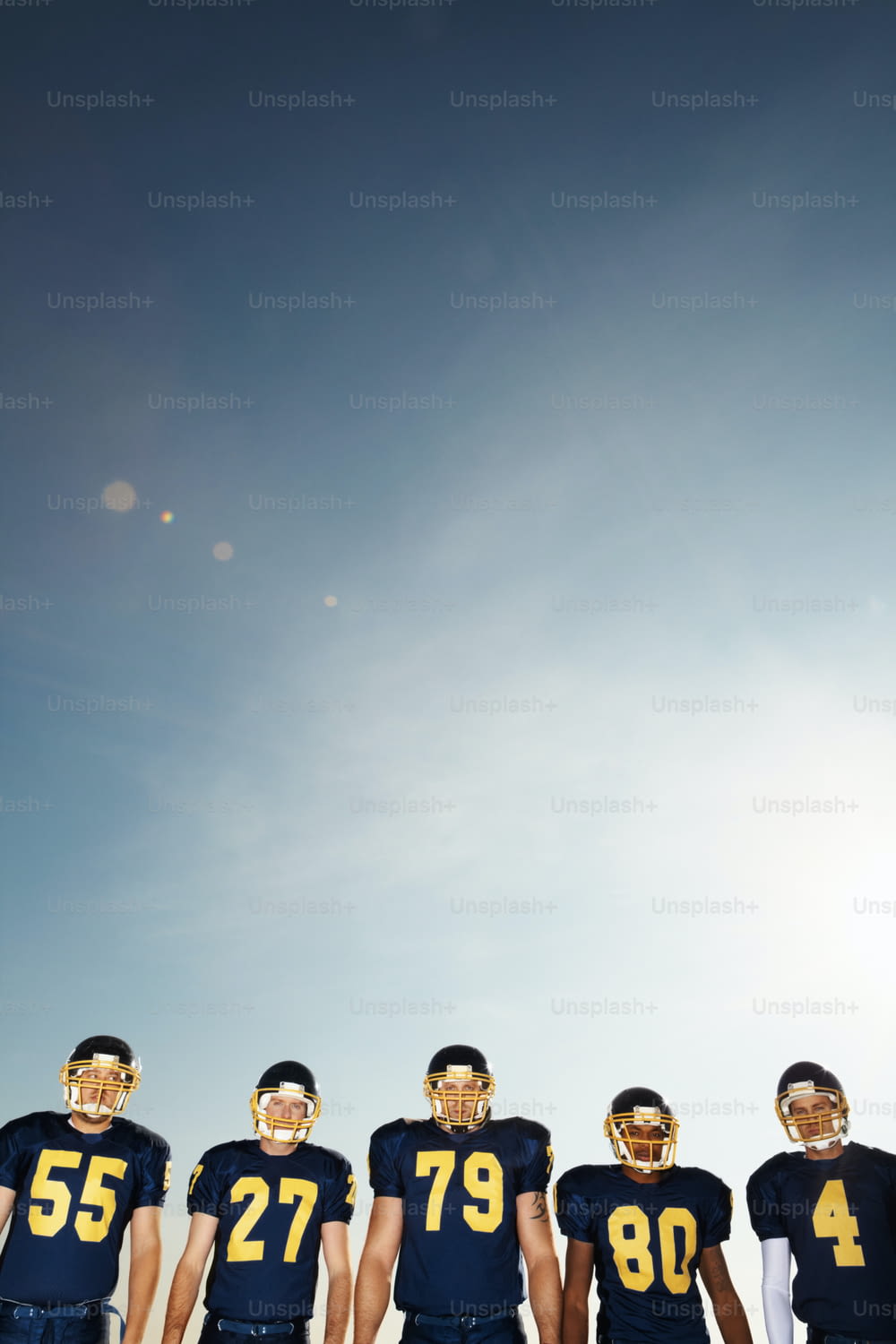 Portrait of a team of pro footballers standing in a line against the clear sky
