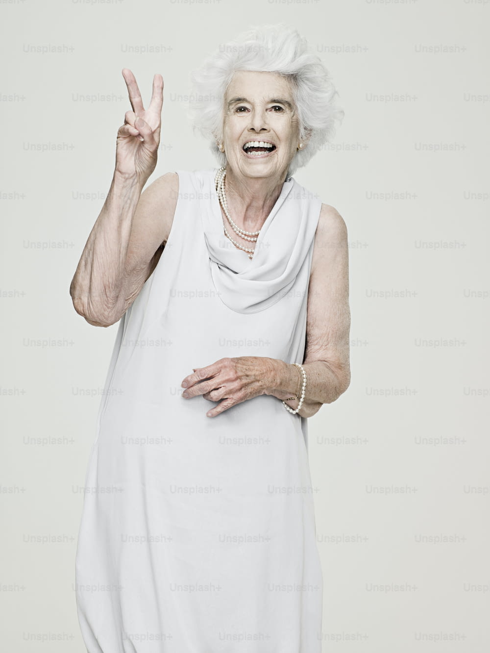 an older woman making a peace sign with her hand