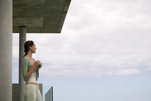 Una donna in piedi su un balcone vicino all'oceano