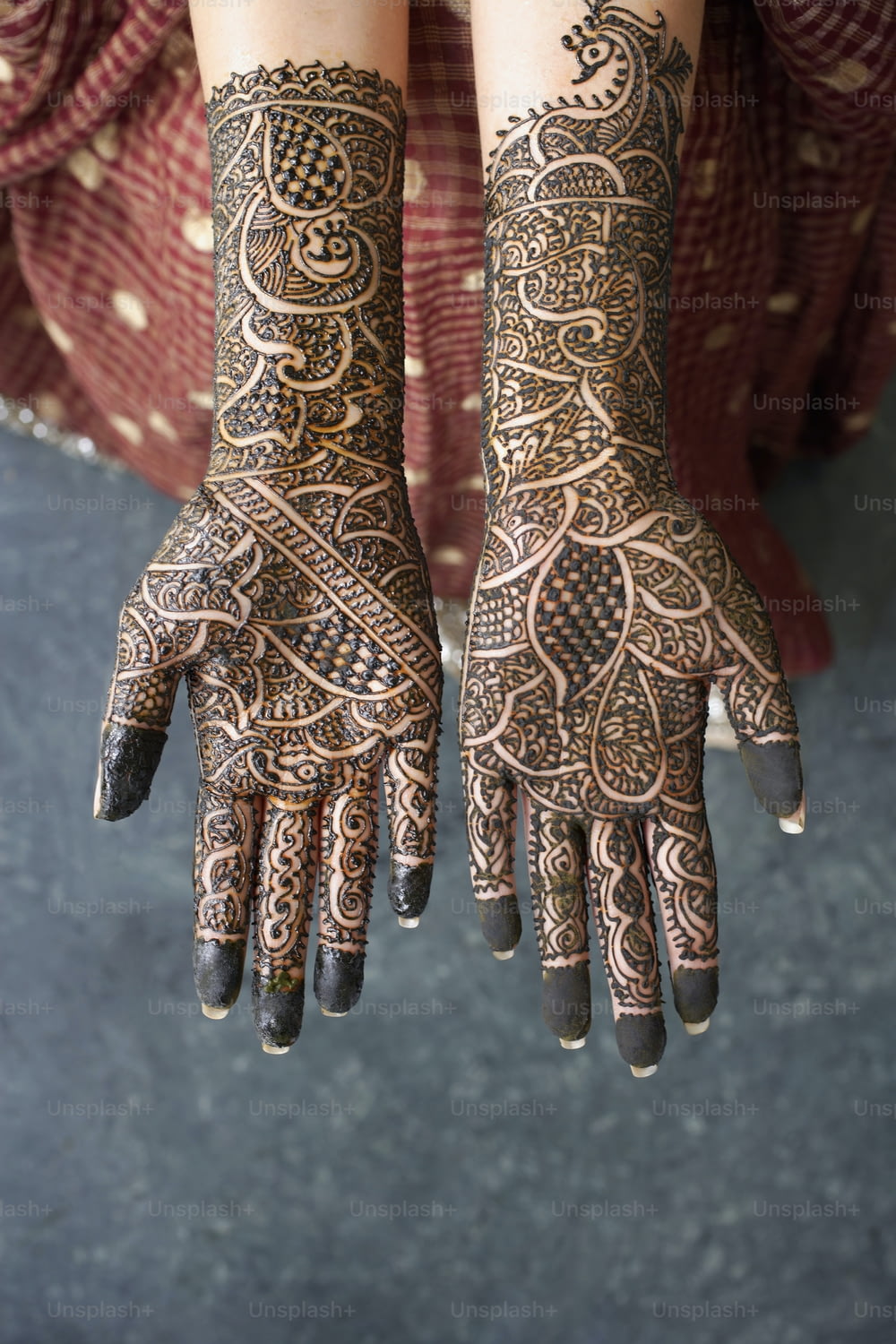 mãos de uma mulher com tatuagens de henna neles