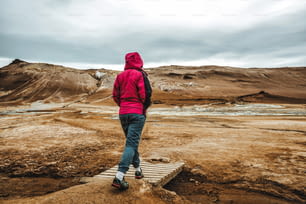 Donna viaggiatrice si reca a Hverir in Islanda. Hverir (in islandese: Hverarond) è un'area geotermica di Myvatn. È una destinazione famosa vicino al lago Myvatn, nella regione nord-orientale di Krafla dell'Islanda, in Europa.