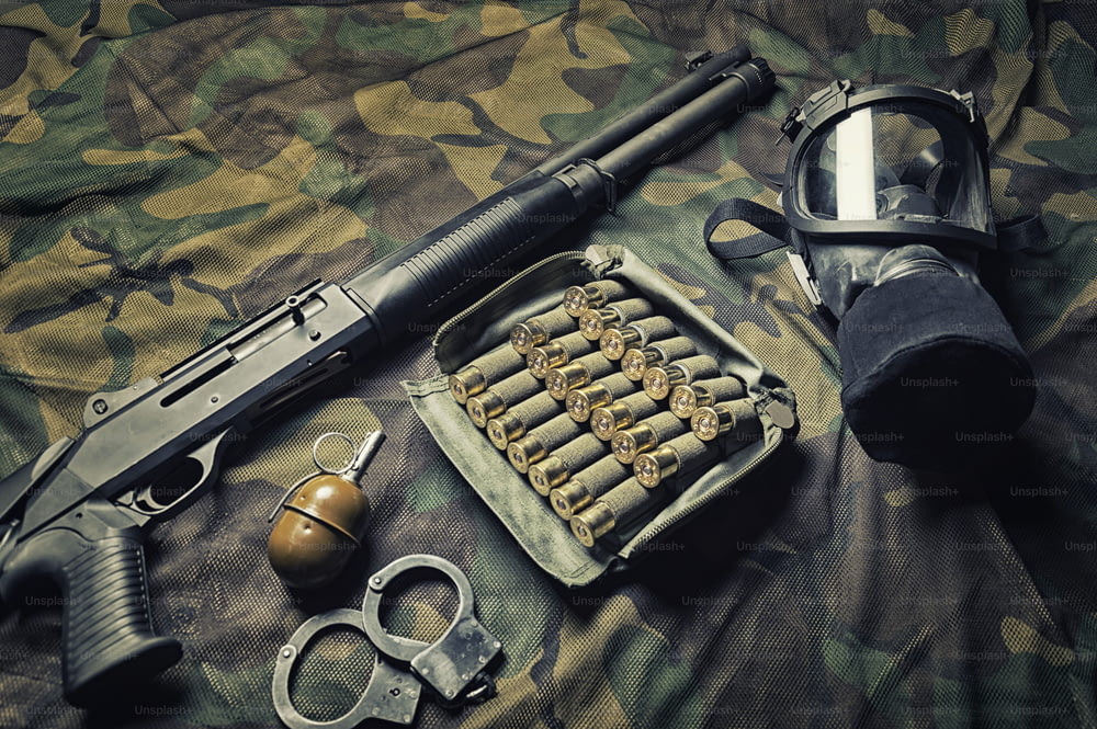 Conjunto de armas de um lutador de uma unidade especial. Espingarda, munição, granada, algemas e máscara de gás. Vista superior. Mídia mista