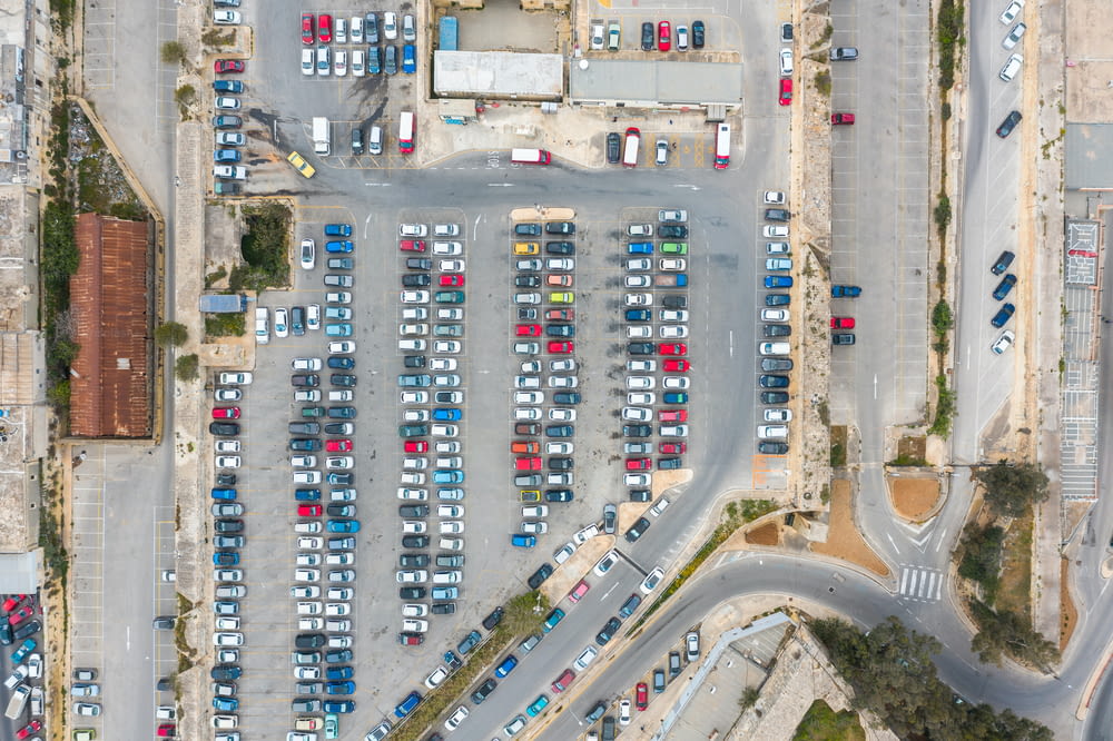 Parken von Autos und Bussen, mit Straßen und einem Halt in der Stadt, Luftbild