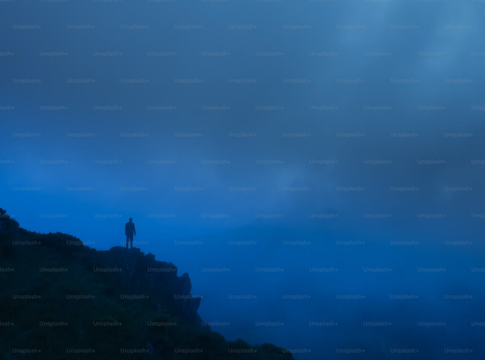 The man standing on the foggy rock. evening night time