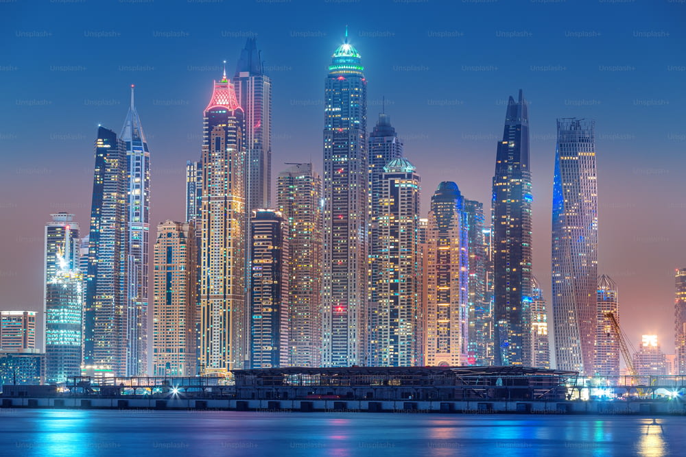 Majestuosa vista de la ciudad de rascacielos y edificios hoteleros en el área del puerto deportivo de Dubái desde la isla de palmeras Jumeirah en Dubai. Atracciones inmobiliarias y turísticas en los Emiratos Árabes Unidos
