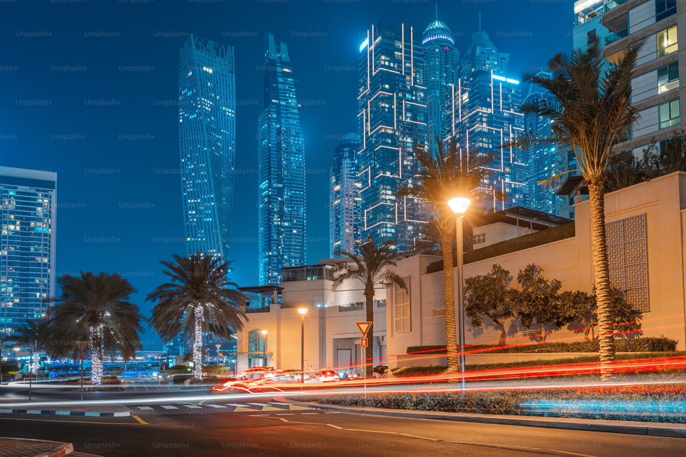 Una foto con una larga exposición con rastros visibles de los faros de los coches que pasan y los rascacielos iluminados en el distrito de Dubai Marina
