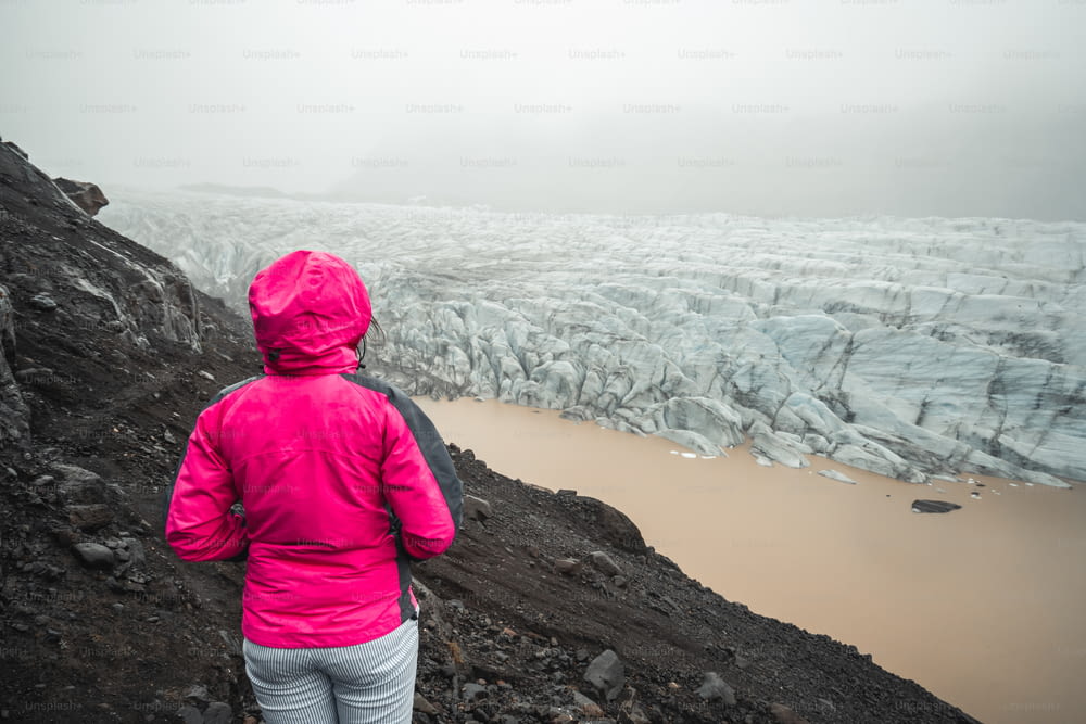La viajera de la mujer viaja en el hermoso paisaje del lago glaciar Svinafellsjökull, destino turístico en el Parque Nacional de Vatnajökull en Islandia. Frío paisaje de hielo invernal.