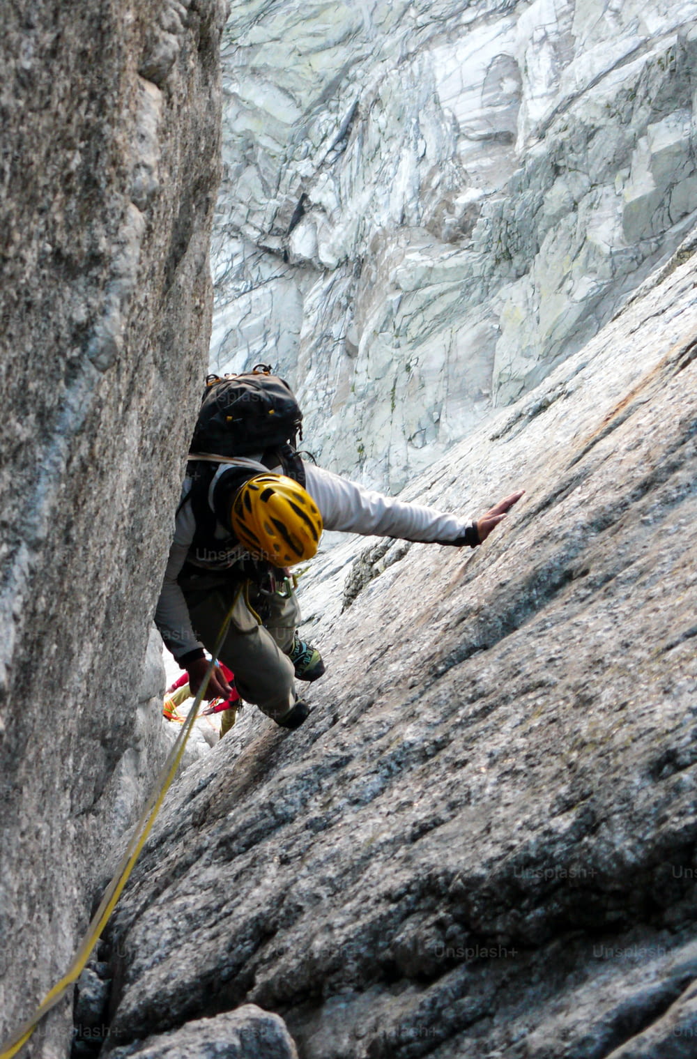 Alpiniste dans une cheminée de granit difficile d’une voie classique dans les Alpes suisses