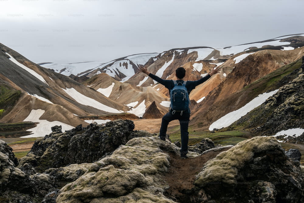 Viajero de senderismo en Landmannalaugar, paisaje natural surrealista en las tierras altas de Islandia, países nórdicos, Europa. Hermoso y colorido terreno montañoso nevado famoso por la aventura de trekking de verano y las caminatas al aire libre.