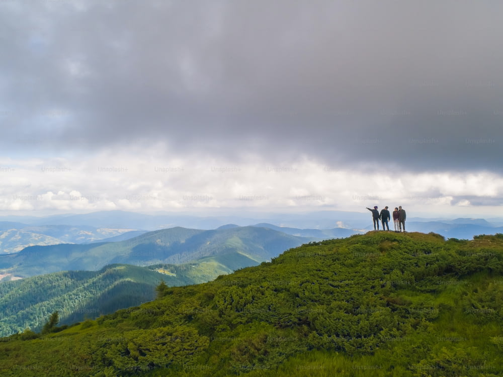 The four people standing on a beautiful mountain against the cloudscape