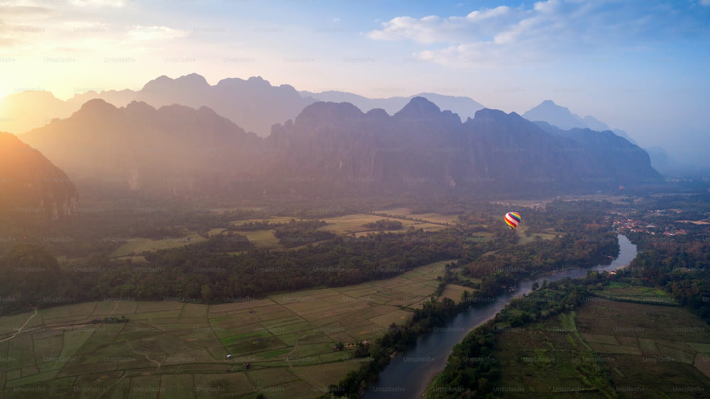 Vue aérienne de Vang vieng avec montagnes et montgolfière au coucher du soleil.