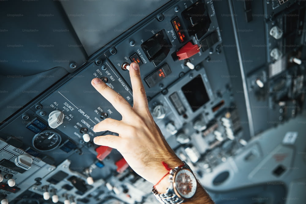 Close up photo of a hand of a pilot touching the switcher in a flight deck and controlling the yaw damper