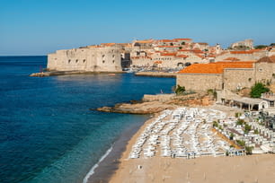 Beach of Dubrovnik Old Town in Dalmatia, Croatia. Banje beach is the most famous Dubrovnik's public beach. Dubrovnik old town was listed as UNESCO World Heritage Sites in 1979.