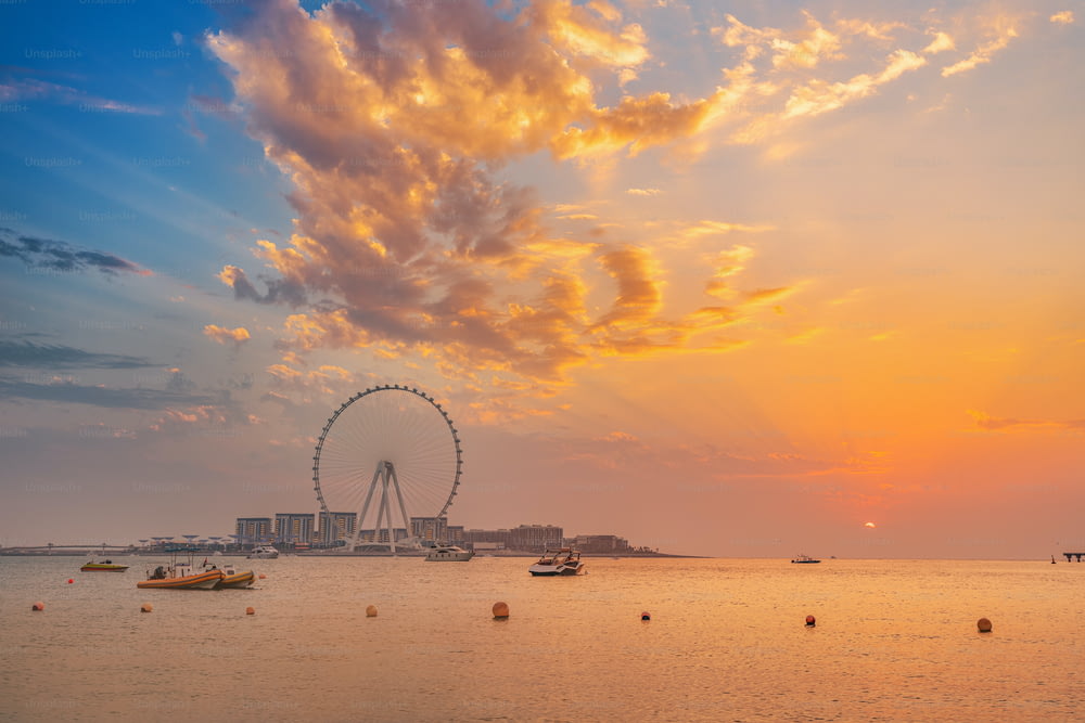 Roter Sonnenuntergang über Bluewaters Island mit dem berühmten Riesenrad Dubai Eye. Panoramablick auf die Stadt und Natur in den VAE
