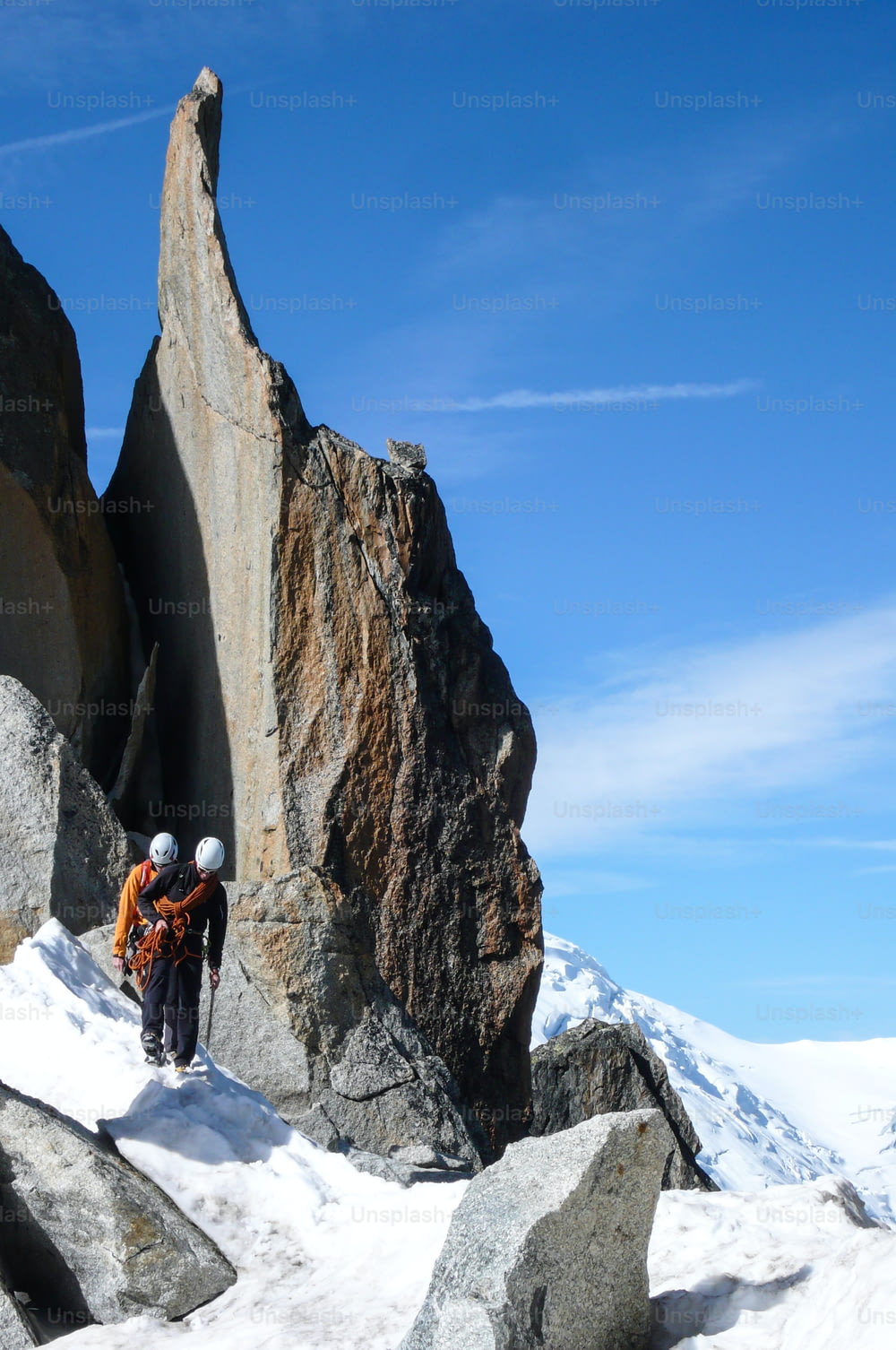 guida alpina e un cliente su una cresta rocciosa in direzione di un'alta vetta delle Alpi francesi vicino a Chamonix in una bella giornata estiva