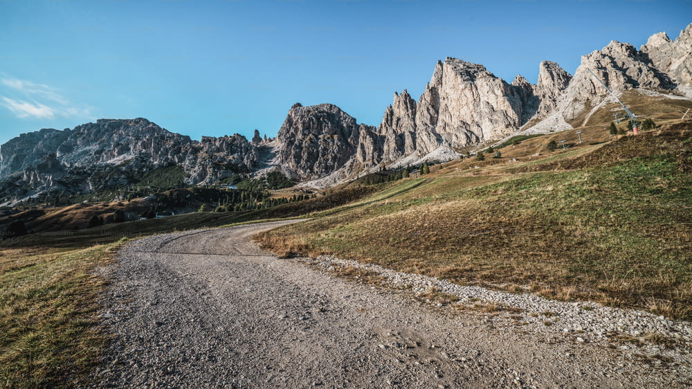 Strada sterrata e sentiero escursionistico in montagna delle Dolomiti, Italia, di fronte alle catene montuose della cresta Pizes de Cir a Bolzano, Alto Adige, Dolomiti nord-occidentali, Italia.