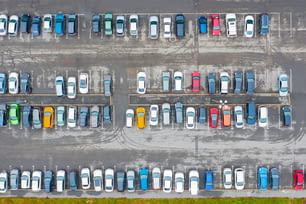 Luftaufnahme von oben auf dem Parkplatz mit Autos im Geschäftsviertel der Stadt, nasser Asphalt