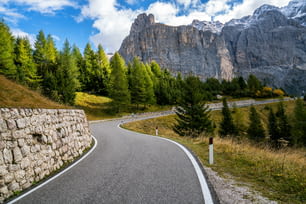 배경에 나무, 숲, 산이 있는 아름다운 산길. 이탈리아 돌로미티 산의 셀라 산 그룹인 파소 가르데나의 주 고속도로 도로에서 촬영.