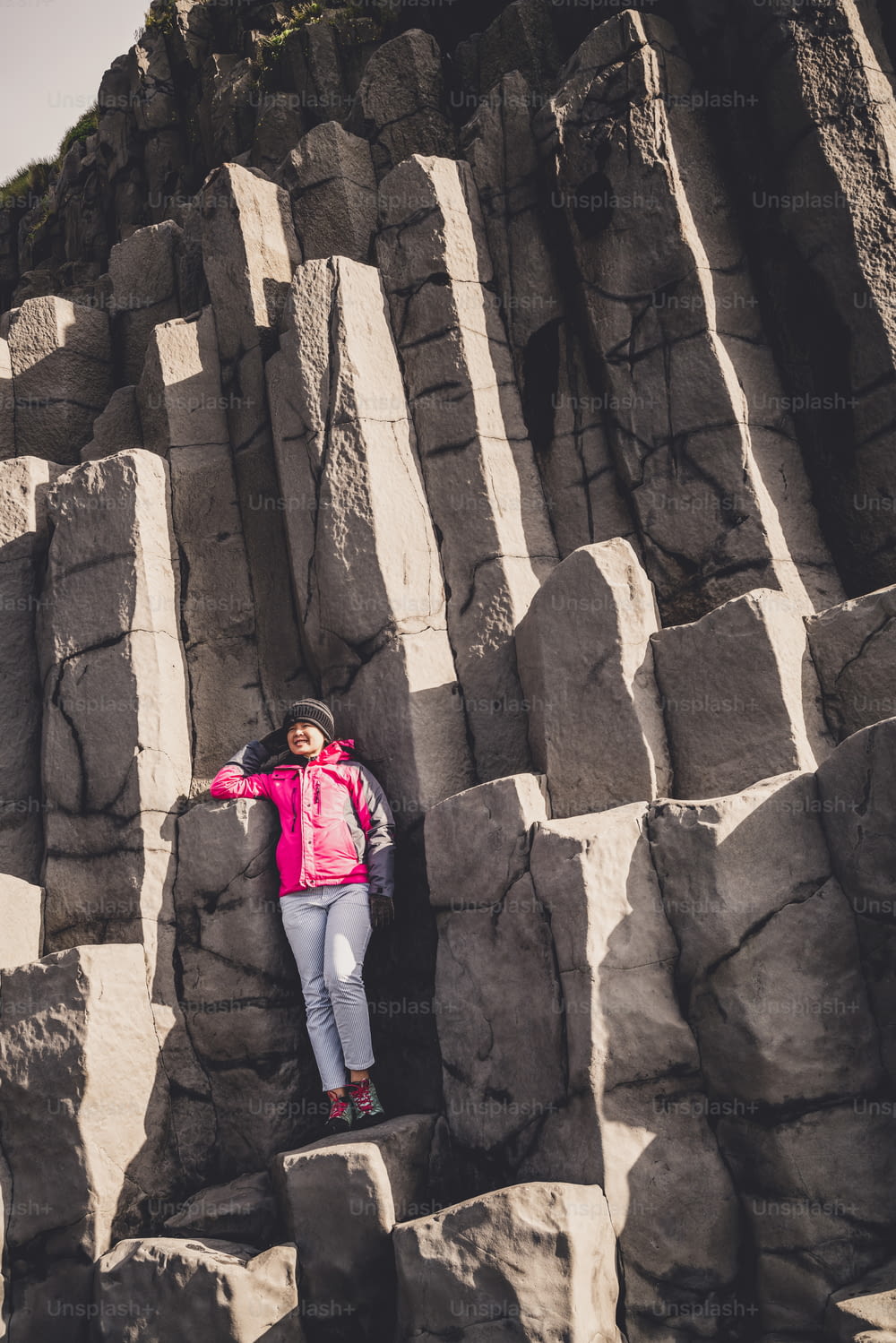 El viajero viaja a una formación rocosa volcánica única en la playa de arena negra de Islandia ubicada cerca del pueblo de Vik i myrdalin en el sur de Islandia. Las rocas columnares hexagonales atraen a los turistas que visitan Islandia.