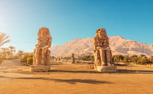 Célèbres deux colosses de Memnon - statues massives en ruine du pharaon Amenhotep III. Sites touristiques et de voyage près de Louxor, Égypte