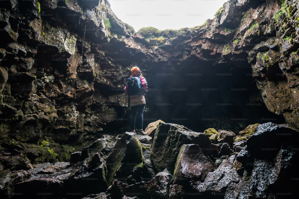 Mulher viajante explorar túnel de lava na Islândia. Raufarholshellir é um belo mundo escondido de caverna. É um dos tubos de lava mais longos e mais conhecidos da Islândia, Europa, para uma aventura incrível.